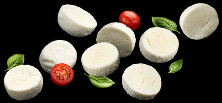 Falling mozzarella cheese slices on black background