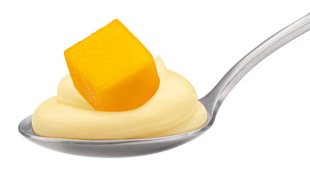 Spoon of fruit yogurt and mango piece isolated on white backgroundの写真素材