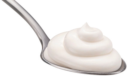 Sour cream in spoon isolated on white backgroundの写真素材