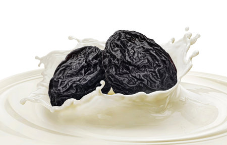 Healthy drink yogurt with dry plum, prune falling into milk splash isolated on white backgroundの写真素材
