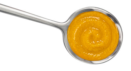 Pumpkin cream soup in spoon isolated on white background. Top viewの写真素材