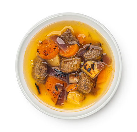 Beef stew with broth, soup with meat and vegetable isolated on white background, top viewの写真素材
