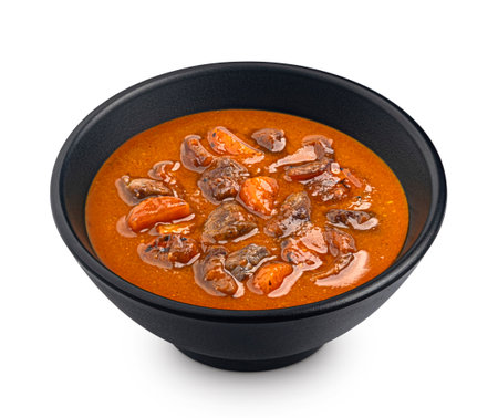 Beef stew in tomato sauce in black bowl isolated on white background, full depth of fieldの写真素材
