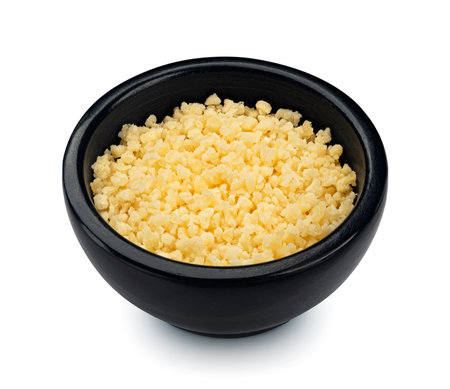 Grated parmesan cheese in black bowl isolated on white backgroundの写真素材