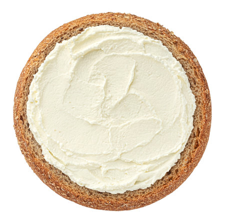 Round slice of rye bread with cream cheese isolated on white background, top viewの写真素材