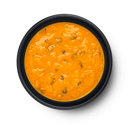 Spicy asian cream soup in black bowl isolated on white background, top view, full depth of fieldの写真素材