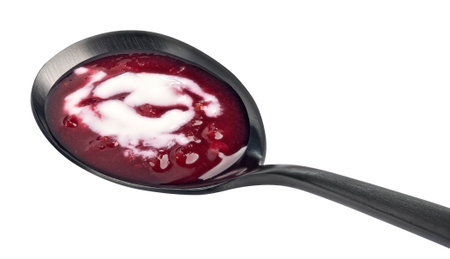 Borscht with sour cream in black spoon, beetroot soup isolated on white backgroundの写真素材