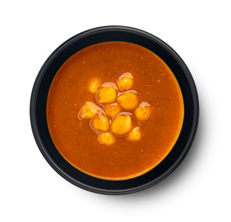 Vegetarian chickpea cream soup isolated on white background, black bowl, top viewの写真素材