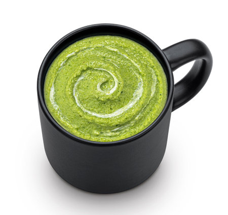 Instant broccoli cream soup in black cup isolated on white background. Top viewの写真素材