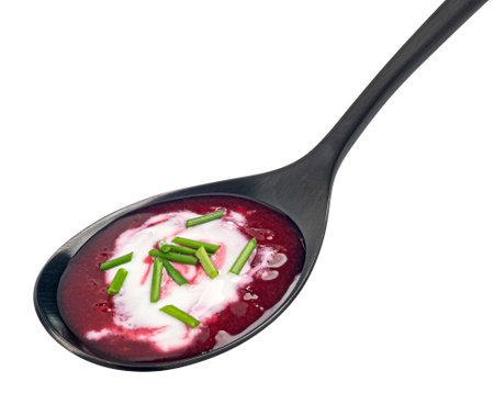 Borscht with sour cream in black spoon, beetroot soup isolated on white backgroundの写真素材