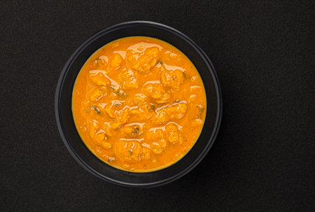 Spicy asian cream soup in black bowl on black background with copy space.の写真素材