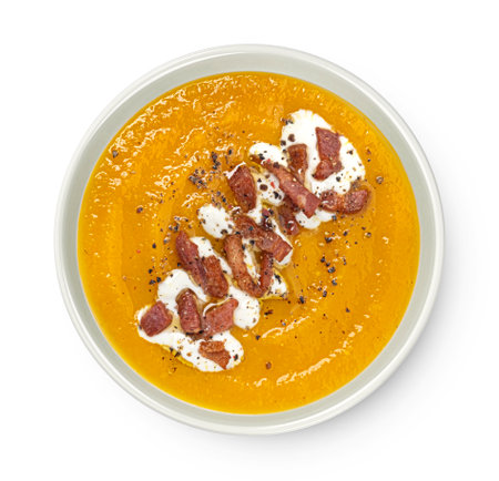 Pumpkin cream soup with pumpkin seeds and crispy bacon isolated on white background, top view, package design elementの写真素材