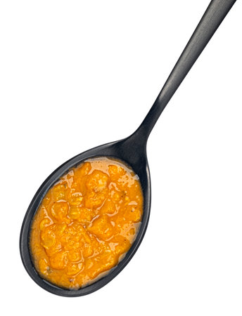 Spicy asian cream soup in spoon isolated on white background, top viewの写真素材