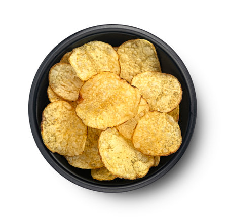 Homemade kettle potato chips in black bowl isolated on white background, top viewの写真素材