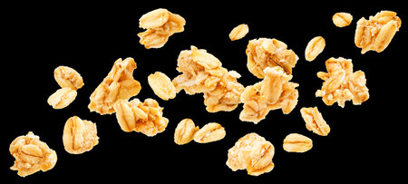 Oat granola, falling crunchy muesli isolated on black background, package design elementの写真素材
