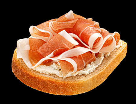 Prosciutto sandwich, jamon on toasted bread slice isolated on black background, package design elementの写真素材