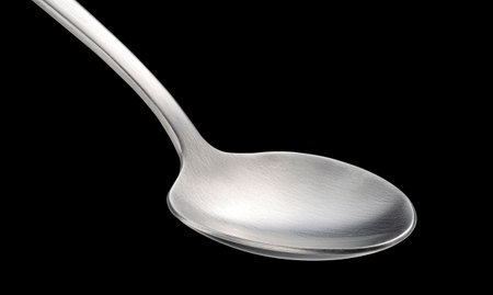 Stainless steel spoon isolated on black background, package design elementの写真素材