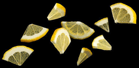 Falling lemon slices on black background, collection of citrus cutsの写真素材
