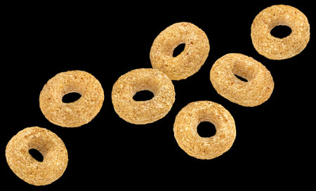 Falling cereal rings isolated on black background, package design elementの写真素材