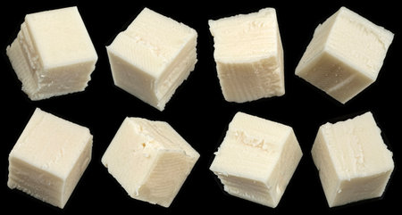 Falling cubes of white cheese isolated on black background, copy spaceの写真素材