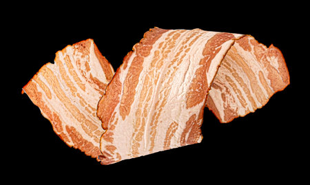 Bacon strip, pork brisket slice isolated on black backgroundの写真素材