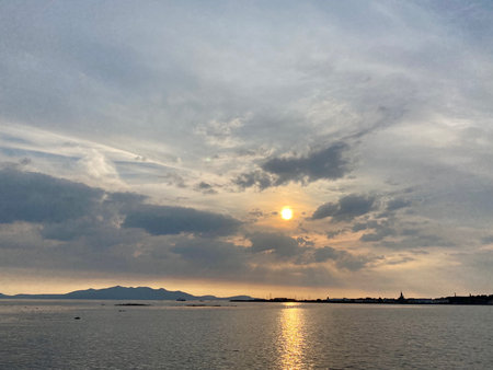 Sunset over the sea with clouds and islands in the background.の写真素材