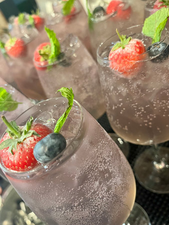 Strawberry and blueberry mojito cocktail with ice cubesの写真素材