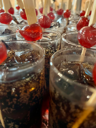 Ice cream with cherries in a glass on a stick, close-upの写真素材