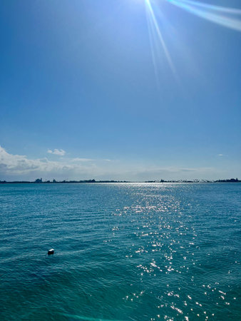 beautiful seascape with a blue sky and sun in the backgroundの写真素材