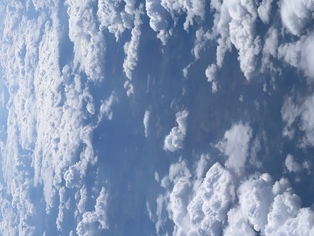 Clouds in the blue sky as seen through window of an aircraftの写真素材