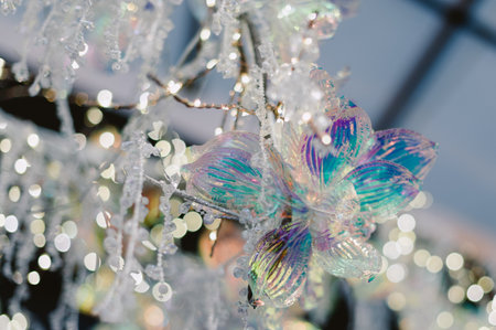 A tree with a blue and white flower on it. The flower is made of glass and is hanging from the treeの写真素材