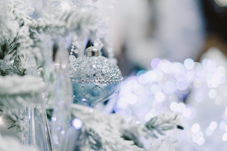 A Christmas tree with a blue ornament hanging from it. The ornament is silver and has a blue designの写真素材