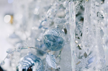 A Christmas tree with a blue ornament hanging from it. The ornament is silver and has a blue designの写真素材