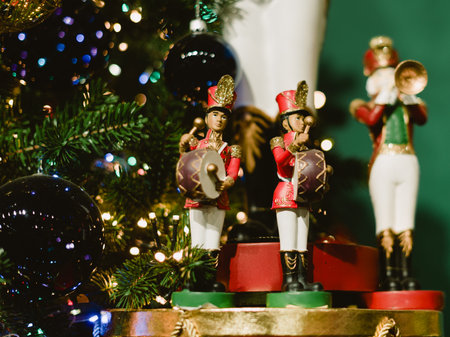 A Christmas tree with a red and gold drum and a green and gold soldier. The tree is lit up with...