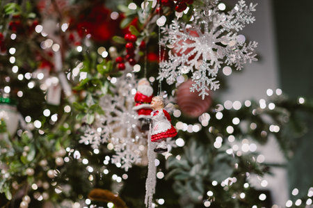 A Christmas tree with a snowflake ornament hanging from it. The snowflake is surrounded by a red and white design.の写真素材