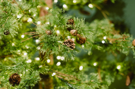 A Christmas tree with a lot of pine cones on it. The pine cones are lit up with lightsの写真素材