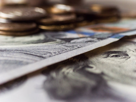 A pile of US currency. The stack is placed on top of another stack of US currencyの写真素材