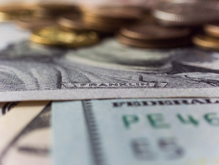 A pile of US currency. The stack is placed on top of another stack of US currency