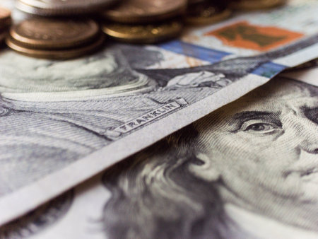 A pile of US currency. The stack is placed on top of another stack of US currencyの写真素材