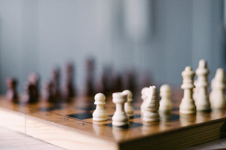 A chess board with pieces on it. The board is black and white. The pieces are arranged in a way that they are ready to play a gameの写真素材