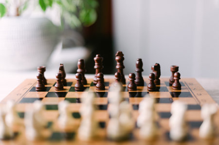A chess board with pieces on it. The board is black and white. The pieces are arranged in a way that they are ready to play a gameの写真素材