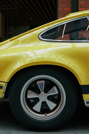 Yellow car with a black stripe on the back. The car is parked in a garage. Phone wallpaper Vertical background.の写真素材