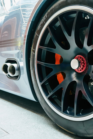 Black tire with the letters SPORT on it. The tire is on a car. The car is parked in a parking lot. Phone wallpaper Vertical background.の写真素材