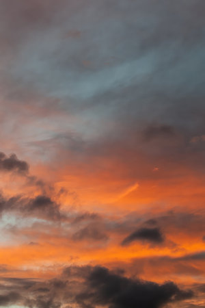 The sky is filled with clouds and the sun is setting, creating a beautiful orange and pink sky....
