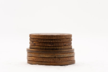 A stack of coins on a white background. The coins are of different sizes and colors.