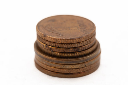 A stack of coins on a white background. The coins are of different sizes and colors.