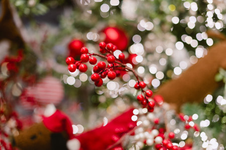 A red and white Christmas tree with red berries. The berries are on the tree and are surrounded by lightsの写真素材