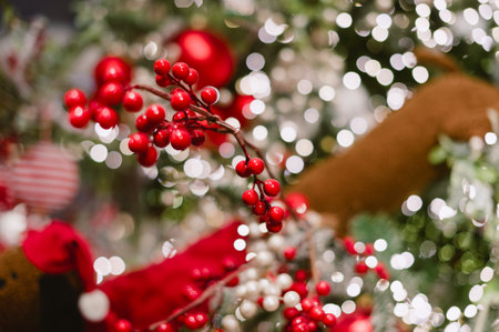 A red and white Christmas tree with red berries. The berries are on the tree and are surrounded by lightsの写真素材