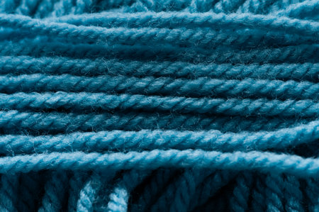 A blue yarn with a lot of knots is shown in the image. The yarn is tightly woven and has a rough...