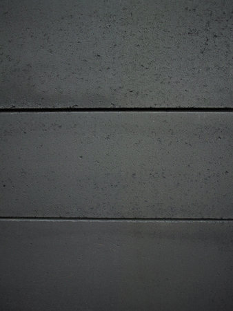 A black wall with a white line. The wall is made of concrete